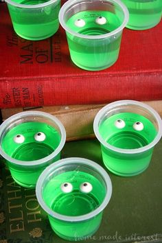 green cups with googly eyes sitting on top of a book