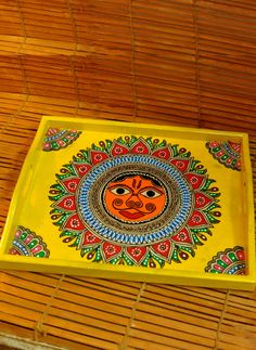 a yellow tray with an orange face painted on it