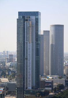 two tall skyscrapers in the middle of a city with lots of buildings around them