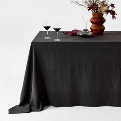 a table topped with two wine glasses and a vase filled with flowers