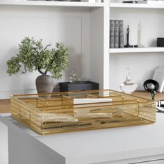 a desk with a wooden box on it and some bookshelves in the background