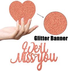 a hand holding a heart shaped glitter banner