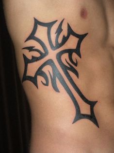 a cross tattoo on the side of a man's stomach