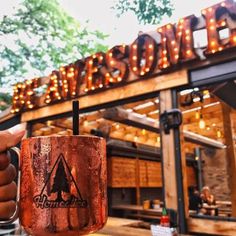 a person holding a coffee mug in front of a restaurant