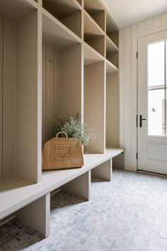 an empty room with some shelves and a basket on the floor in front of it