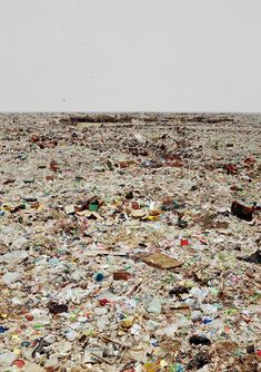 a large amount of trash is in the middle of an open field with no one on it