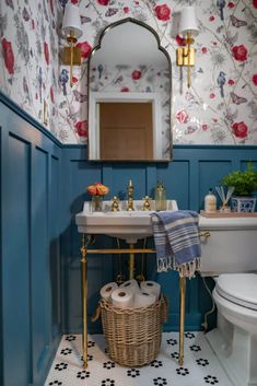 a white toilet sitting next to a bathroom sink under a mirror in a blue room