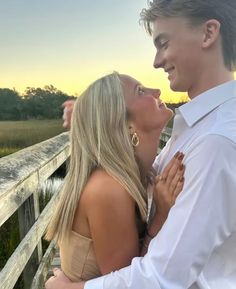 a man and woman standing next to each other on a bridge