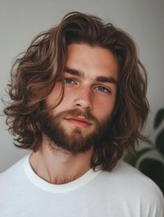 In this photo, the model’s shoulder-length hair is styled in loose, bohemian waves. His medium brown hair flows naturally, enhancing his relaxed and artistic appearance. This style is great for men who love a free-spirited and creative vibe. I’ve styled similar bohemian looks for clients who appreciate a more natural and effortless hairstyle. The waves add a touch of bohemian charm, making it a perfect choice for those with an artistic flair. Length Hair Men Long, Shoulder Length Mens Hairstyles, Long Haircut For Men Wavy, Brown Hair Guy Aesthetic, Medium Length Haircuts For Guys, Kit Harrington Style, Hazelnut Brown Hair, Men Brown Hair, Men With Brown Hair