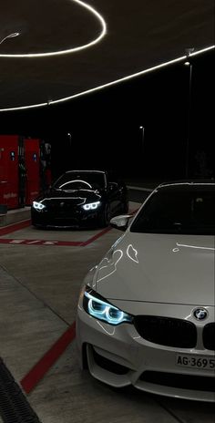 three cars parked in a parking garage with lights on the front and side of them