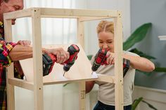 a man and woman are working on a wooden structure with drillers in their hands