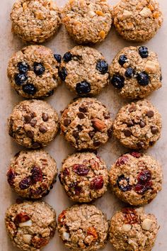 several cookies and muffins laid out on a sheet of parchment paper with blueberries, almonds, and cranberries in the middle