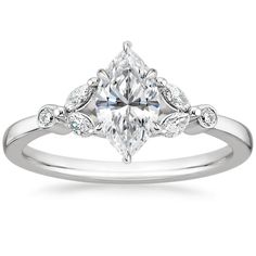 an engagement ring with a pear shaped diamond in the center and leaves on each side