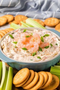 a bowl of shrimp dip surrounded by crackers and celery