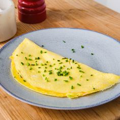 an omelet with chives on a blue plate