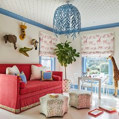 a living room filled with furniture and a giraffe hanging above the couches