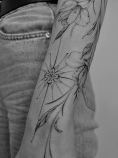 a woman's arm with a flower tattoo on the left side of her arm