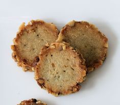 some cookies are on a white plate and one is cut in half to show the filling