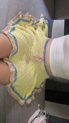 a woman's legs wearing yellow socks with blue and white laces on them