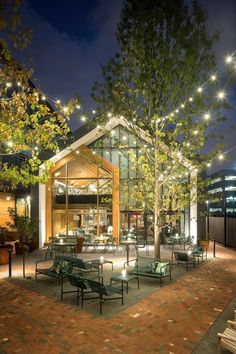 an outdoor seating area is lit up at night with string lights strung from the trees