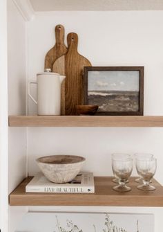 two shelves with wine glasses and other items on them