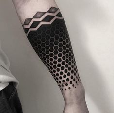 a man's arm with a black and white geometric pattern on the left forearm