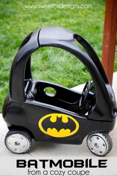 a batman car toy sitting on top of a cement slab with the words batmobile from a cozy coupe written below it