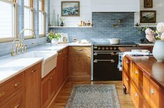 a kitchen with wooden cabinets and white counter tops, blue tile backsplashes