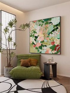 a green chair sitting in front of a painting on the wall next to a potted plant