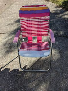 a colorful lawn chair sitting on top of a sidewalk