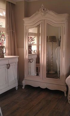 a white dresser and mirror in a room