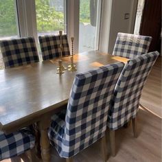 a dining room table with blue and white checkered upholstered chairs next to it