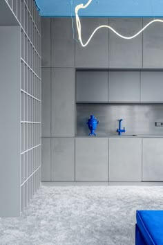 a blue bench sitting in the middle of a room next to a wall with shelves