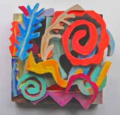 an art piece made out of colored paper with swirls and leaves on the sides