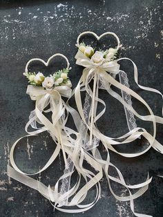 two wedding garters with white flowers and ribbons