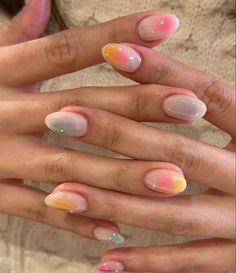 two hands with different manies and one has pink, yellow and white designs on them