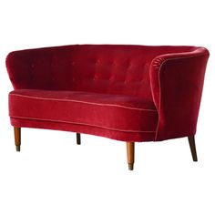 a red couch sitting on top of a wooden frame