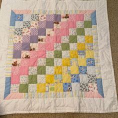 a baby quilt is laying on the floor