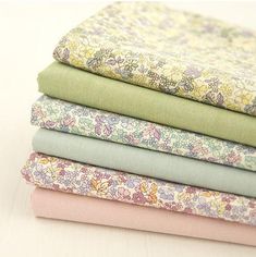 four different colors of fabric stacked on top of each other in various sizes and patterns