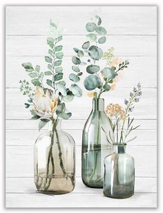 three glass vases with flowers and greenery in them