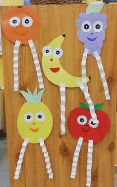 paper plate fruit and vegetable puppets on a wooden board