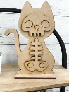 a wooden cutout of a cat with a skeleton on it's back sitting on a table