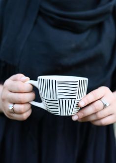 a woman holding a coffee cup in her hands