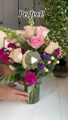 a vase filled with lots of flowers on top of a table