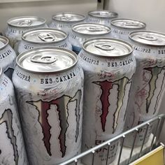 several cans of monster energy drink in a refrigerator