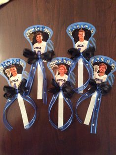 four hair clips with photos of the same person on them, tied together in blue and white ribbons