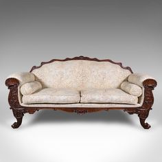 an old fashioned couch with ornate carvings on the armrests and back rest,