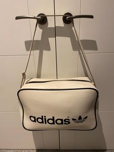 Thank You for visiting beats and treats and viewing this item. This Vintage Adidas Bag is in good Condition having been  well cared for . Finished in a mid off white  with black  logo's. A more unusual find Manufactured in the UK  for Adidas  S.A.R.L ( France ). It has all the hall marks of a Peter Black bag ..  The logo on the rear is interesting and hard to establish exactly what it represents. Having done a bit of reaearch I ammof the view the back is a commision for an Ice Hockey team .  How Adidas S, Adidas Bag, Adidas Bags, Adidas Vintage, Sports Bags Gym, Hockey Team, Sport Gym, Vintage Adidas, Black Bag