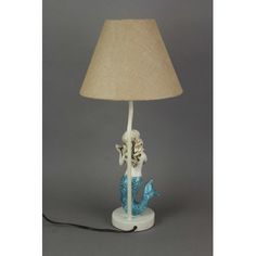 a lamp with a mermaid on it and a light shade over the top of it