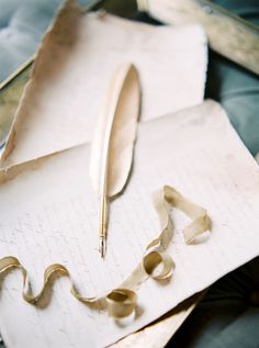 a pen sitting on top of a piece of paper next to a pair of scissors